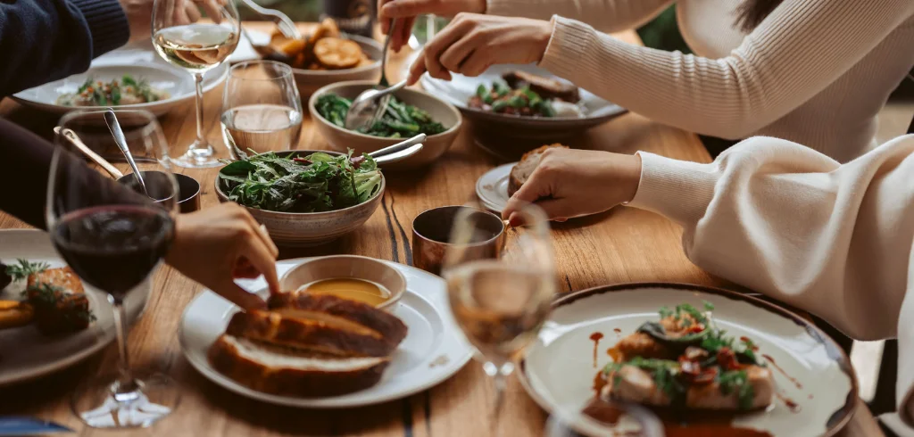 Guests sharing a meal and wine around a table at Coombe Estate