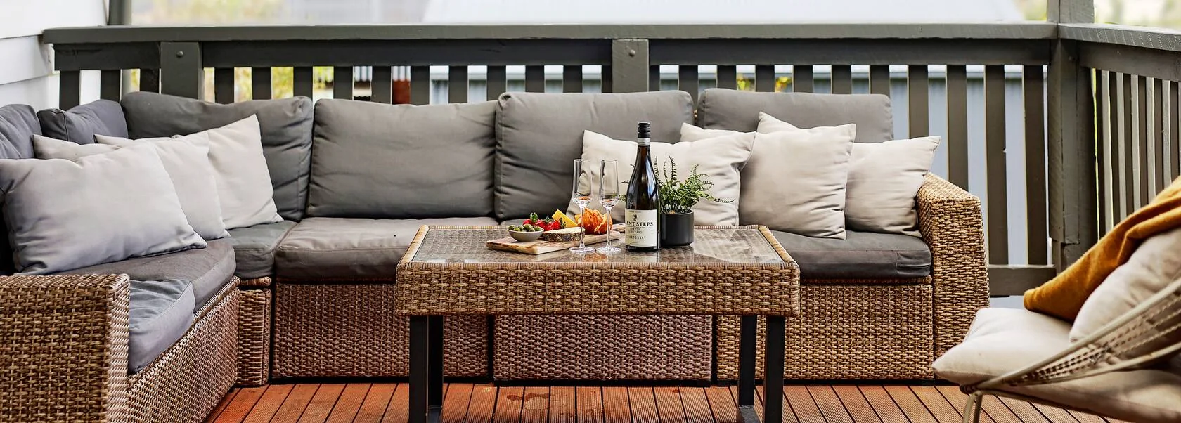 Covered deck lounge with cushions, wine glasses and a grazing board
