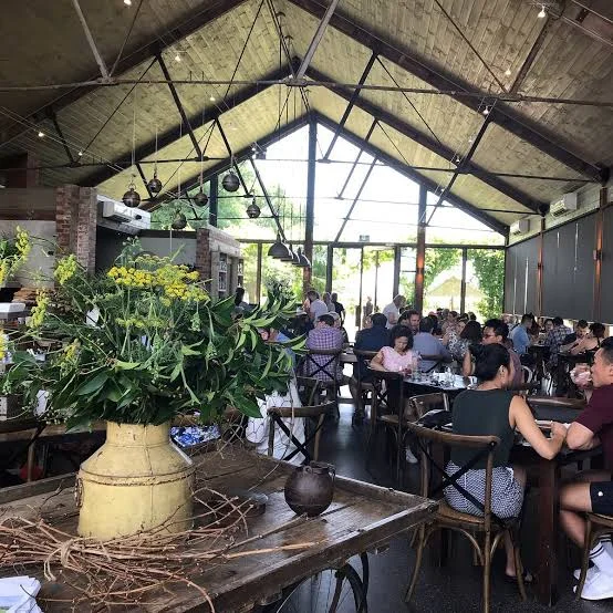 Guests seated beneath the pitched timber roof at Napoleone Cider Co.