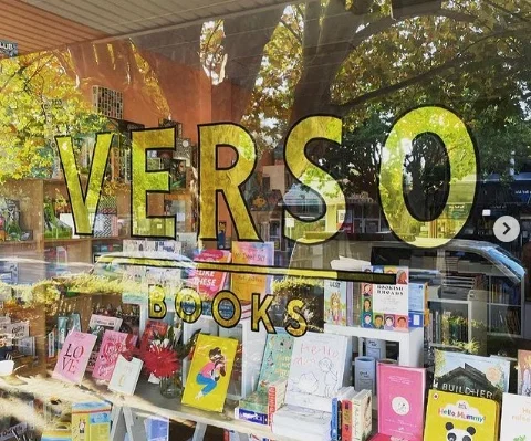 Verso Books’ shop window filled with books beneath its gold lettering